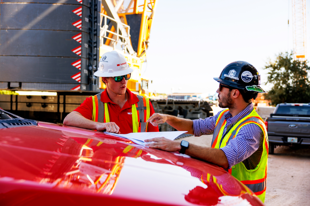 Project supervisors review construction plans and daily schedules on site, ensuring coordination between multiple crews working on different phases of the Brooks Bridge Replacement.