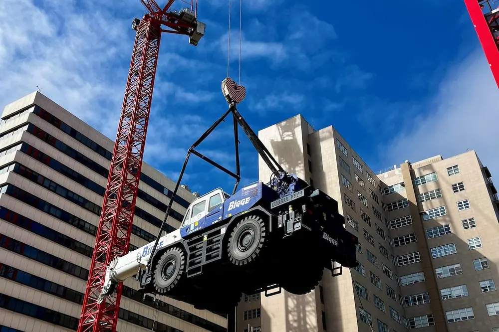 The cranes lower a mobile crane weighing approximately 38 tons into the basement level.
