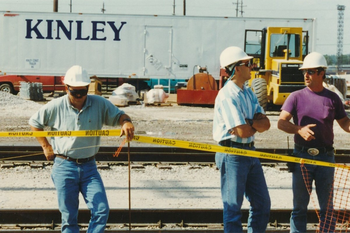 John and Angelo Crisafulli, part of the fifth-generation Kinley leadership team, work on a railroad job site with 50-plus year Kinley veteran Don Wilcox in the 1990s.