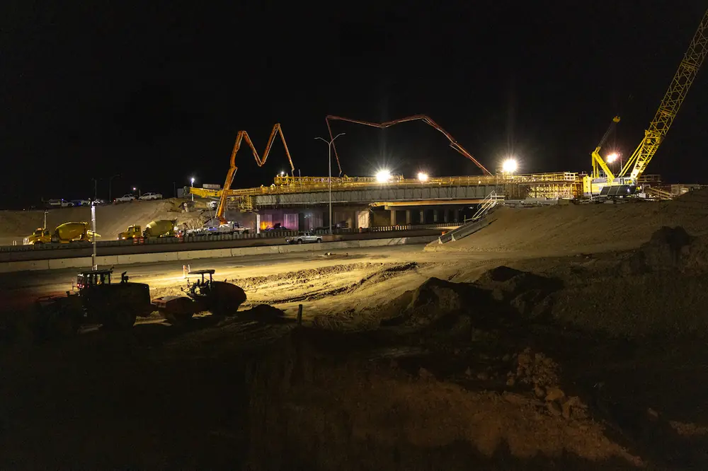 Pictured here is a wide view of the Montgomery deck pour over I-25. Because of the size of the deck, two concrete pump trucks were used to move all the concrete in one night.