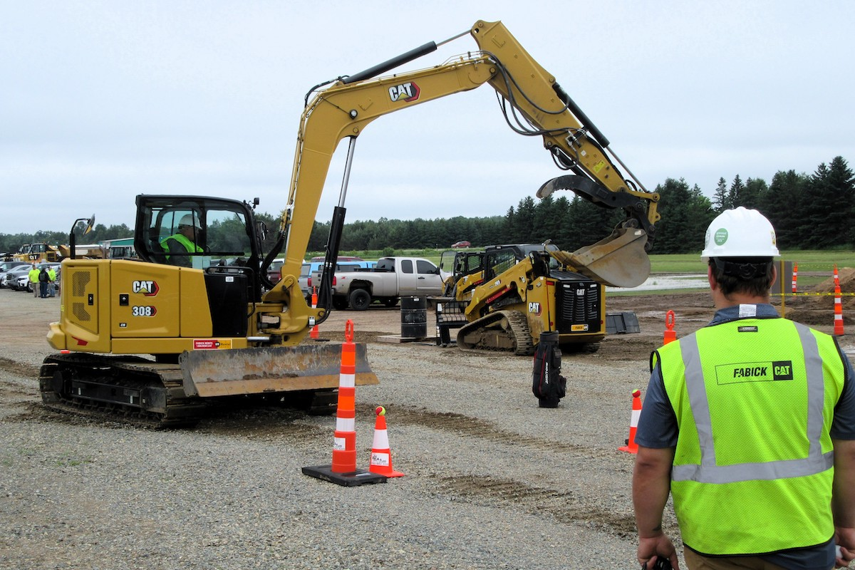 A 308 Caterpillar Mini Excavator plays on the golf course.