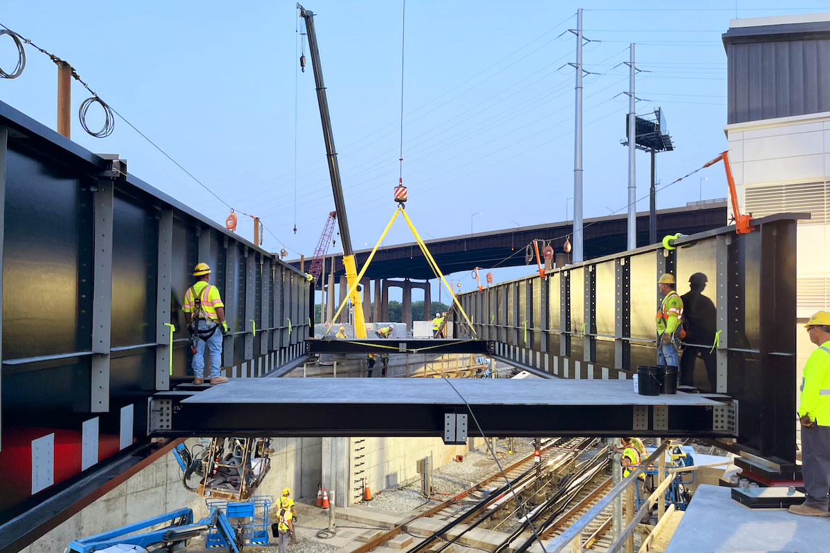The crew slides the prefabricated floorbeam panels into place.