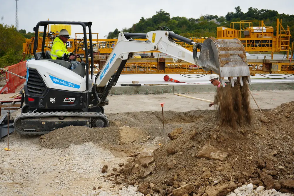 A KCI Operator moves earth material to prepare the area for bridge rehabilitation.