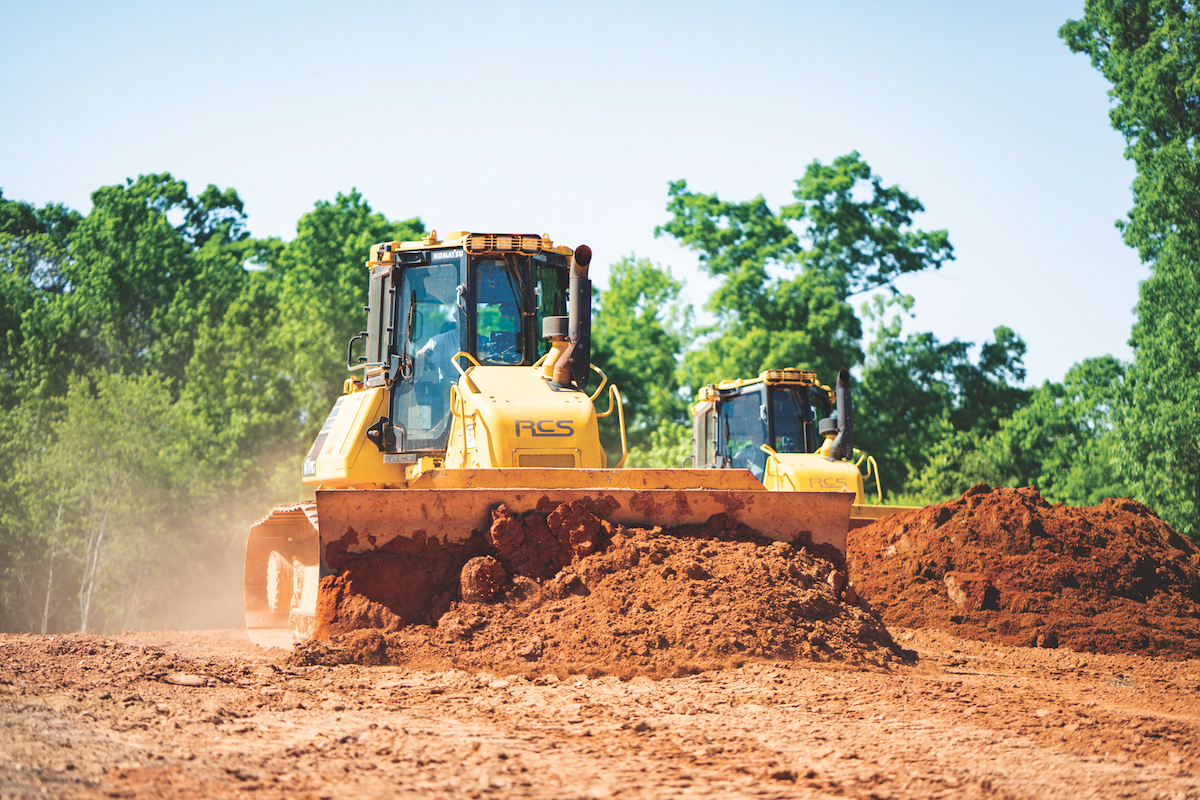 A pair of operators grade a site with Komatsu Intelligent Machine Control dozers.