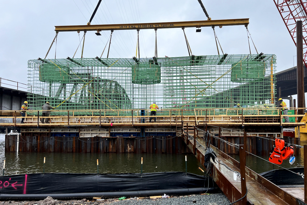 The crew hoists the complete Pier 1 reinforcement cage into place.