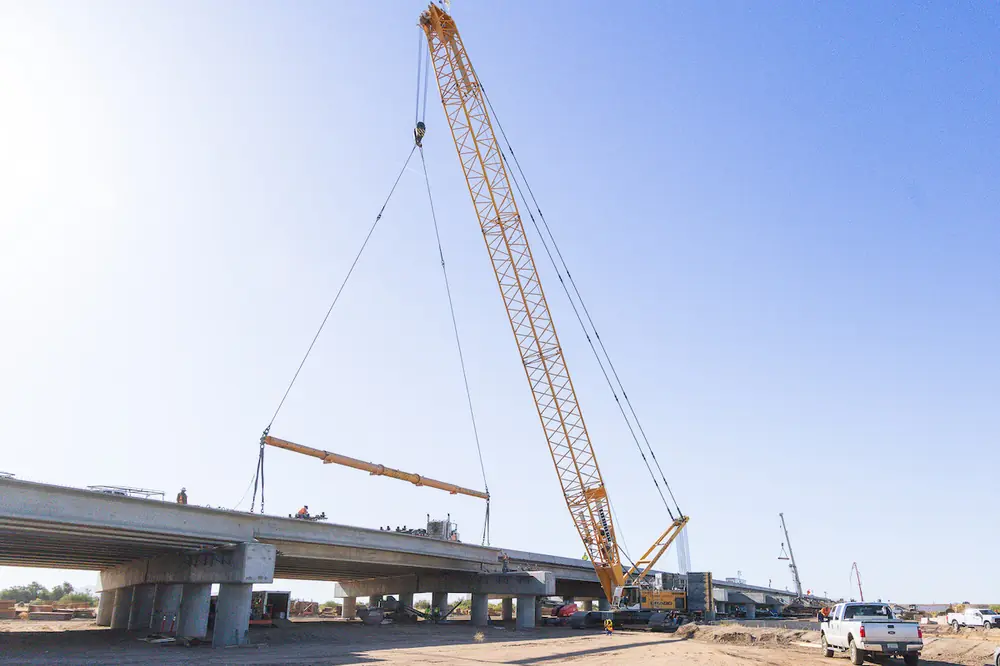 Crews set girders on one of the two new bridges over the Gila River in Arizona.