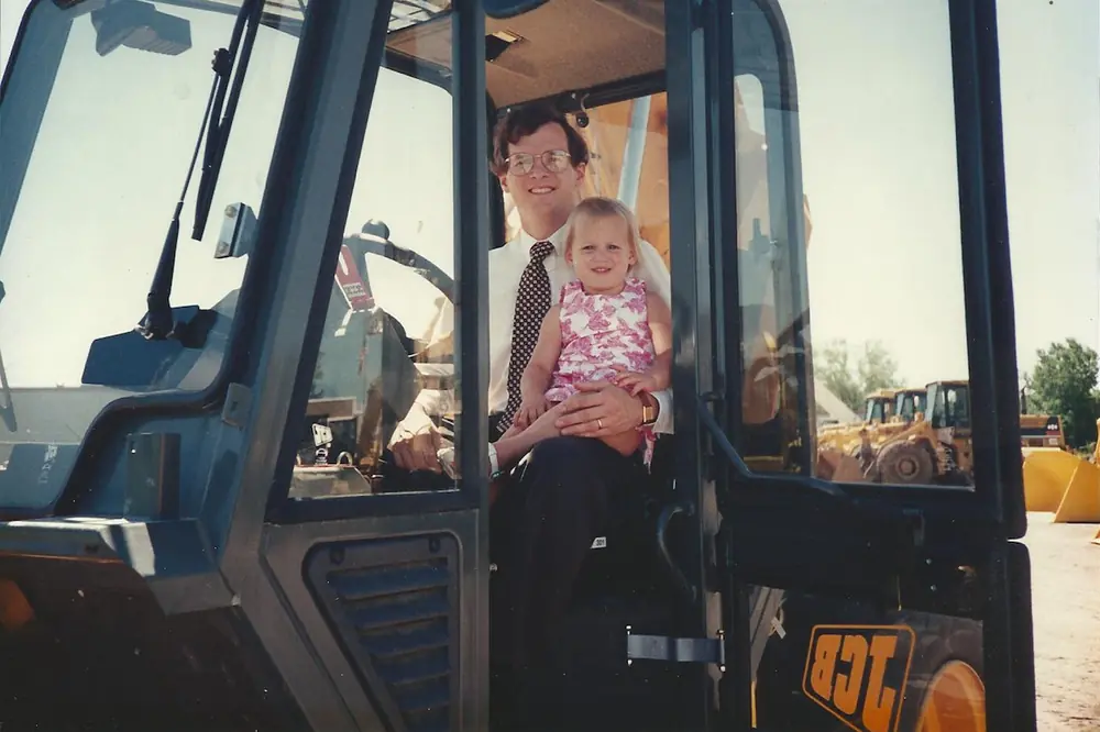 In 1996, Mike M. Sill II sits in a JCB forklift with his daughter, Abby Sill.
