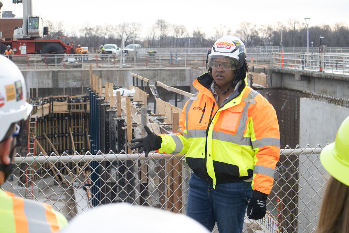 An Assistant Project Manager addresses visitors during a job site tour at the Kansas River Wastewater project for Women in Construction Week.