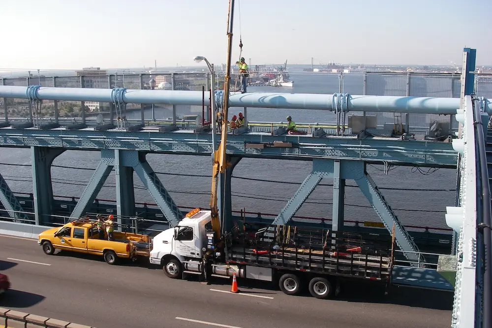Contractors work on the cables of the Benjamin Franklin Bridge.