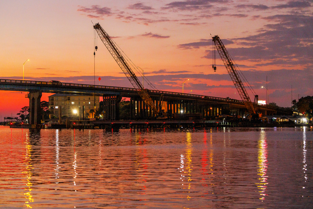 A sunset view of the Brooks Bridge project shows multiple Superior Construction cranes.