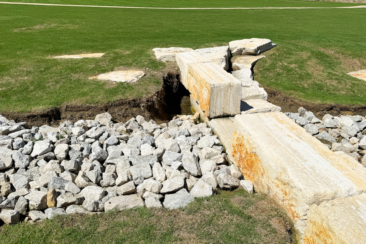 An inadequate drainage system causes erosion damage.