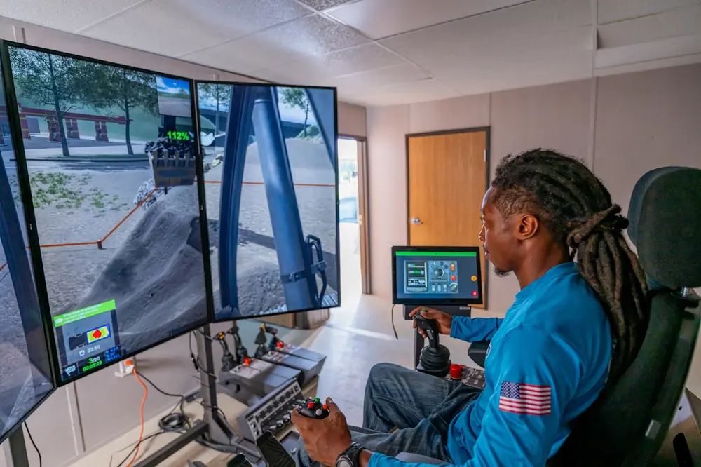 A Superior Construction apprenticeship student training on a heavy equipment operator simulator.