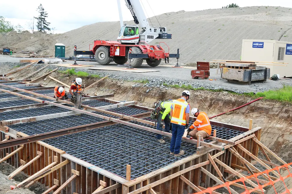 Crews place a bridge abutment footing for a future bridge at South 188th Street in SeaTac.