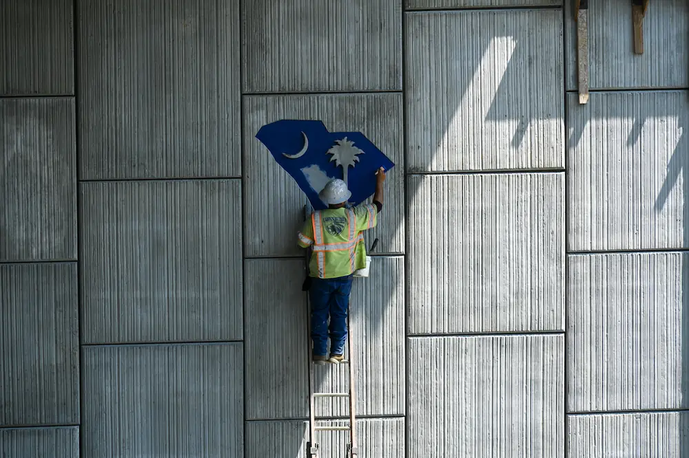 Blue paint is applied to a South Carolina state emblem, which is embossed in one of the mechanically stabilized earth wall slabs underneath the I-77 Exit 26 overpass bridge in Richland County.