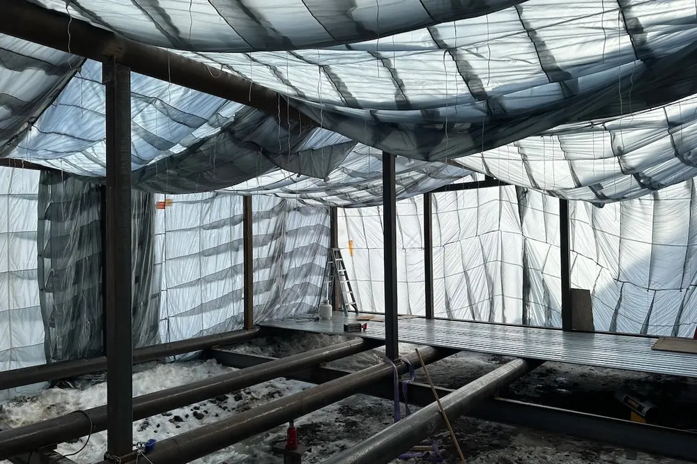 Welders used retired military cargo parachutes to create a heat dome that allowed them to continue working on structures through subzero winter weather.