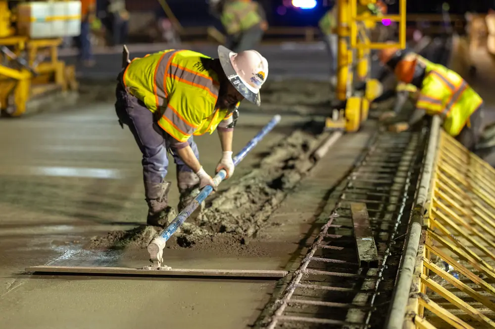 A worker removes the tracks laid by the concrete leveling machine.