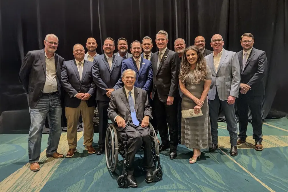 Governor Greg Abbott (front) takes a photo with TACA President Andrew Pinkerton (sixth from the right) and TACA members at the CIM Scholarship Gala.