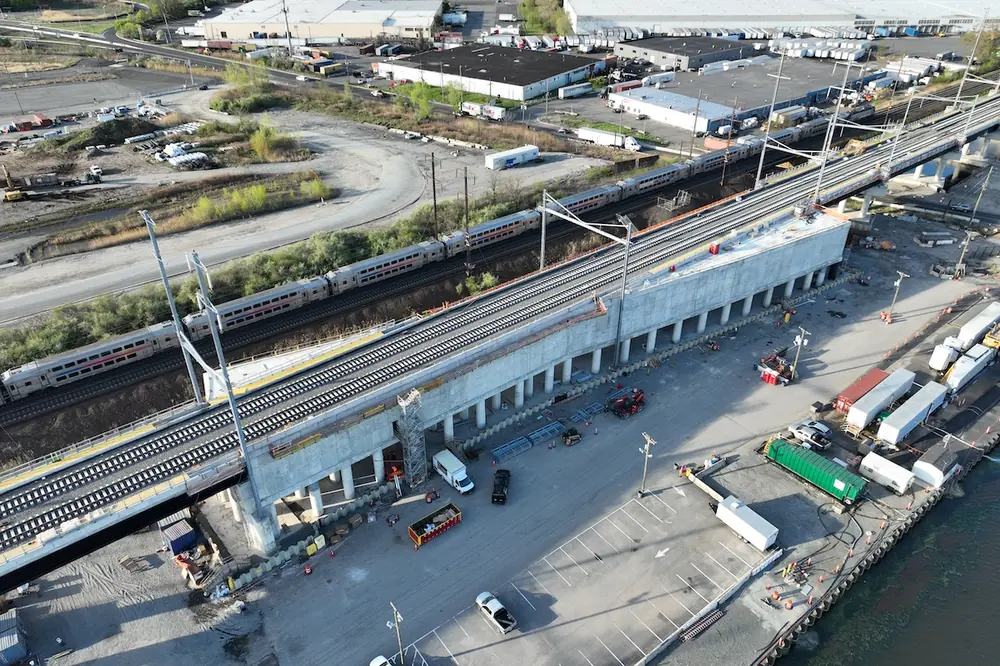 Work on the bridge continues as trains maintain their schedules. (Photo courtesy of Skanska)
