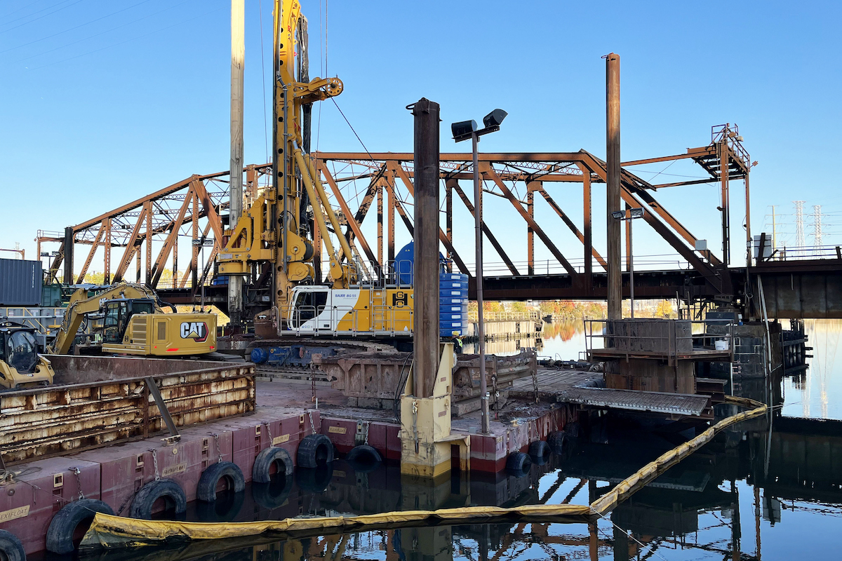 The George Harms Construction Company's drilled shaft construction operation features a Bauer BG 55 Drilling Rig, spoils hopper, and de-sanding unit.
