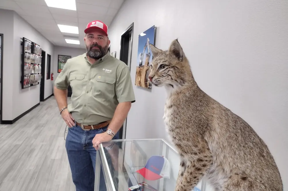 John Bovee, Waco Bobcat Branch Manager, poses with the branch mascot.