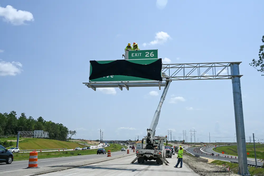 One of the new I-77 Exit 26 signs is installed. This exit will lead freight to the under-construction Scout Motors facility, and motorists to U.S. 21 via a new connecting roadway.