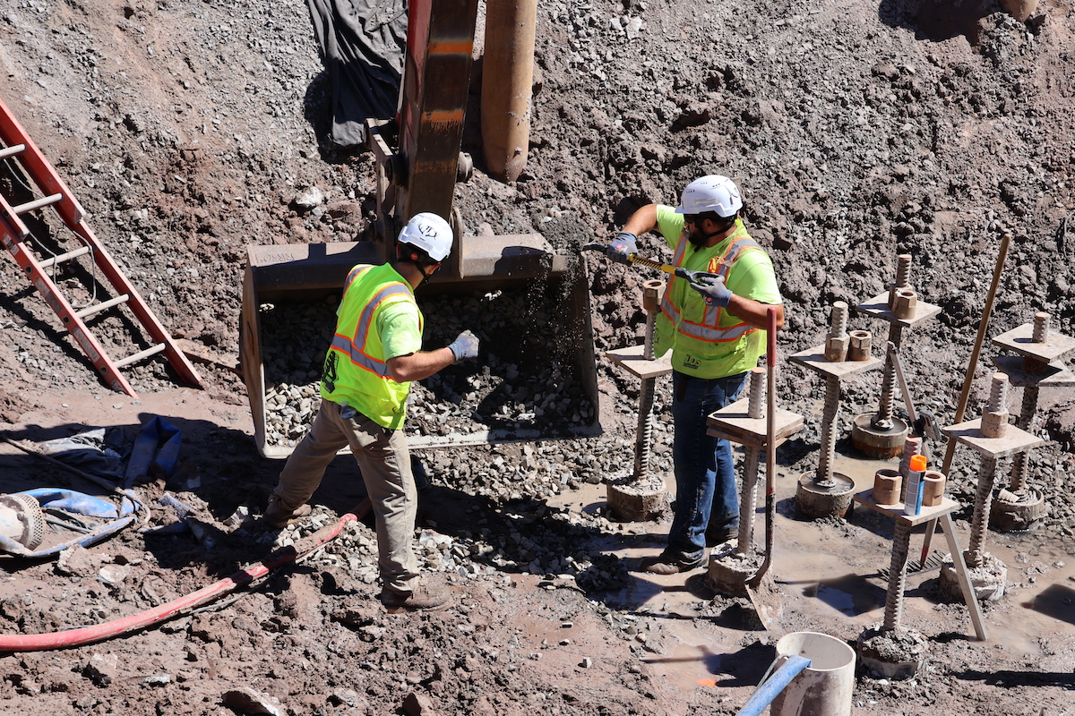 Workers from The DDS Companies of West Henrietta, New York, direct the application of stone at one of the footing locations.