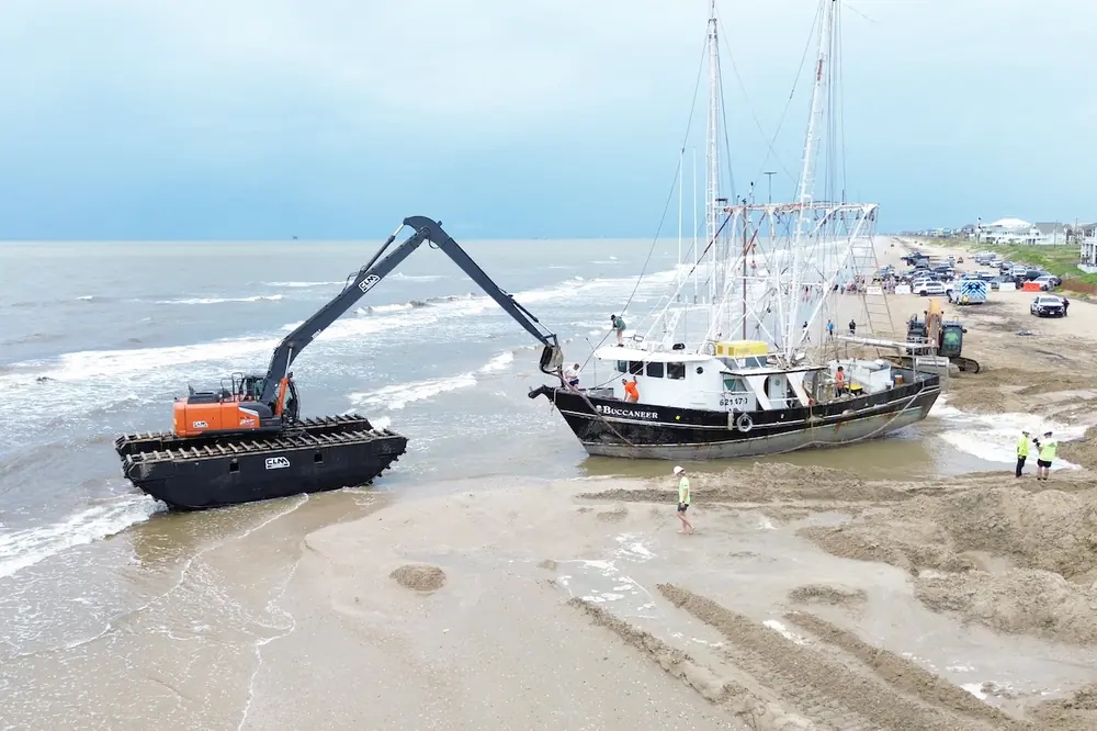 After a commercial shrimp boat was stranded on a beach, CLM’s amphibious pontoon excavator was used to dredge out the thick sand around the grounded hull.