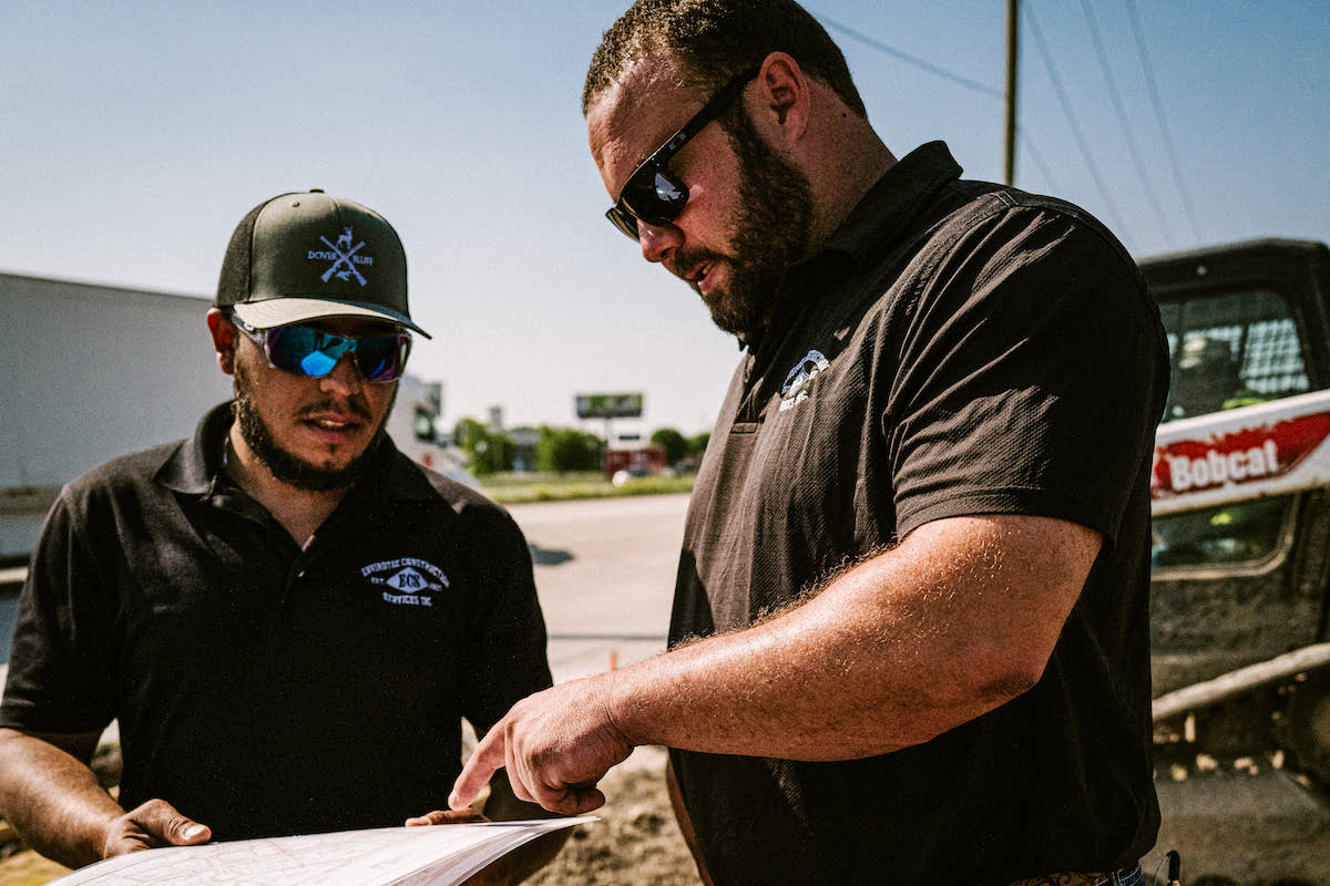 Robert Satterfield, Operations Manager for Grade Divisions for ECS (right), reviews project plans with a colleague.