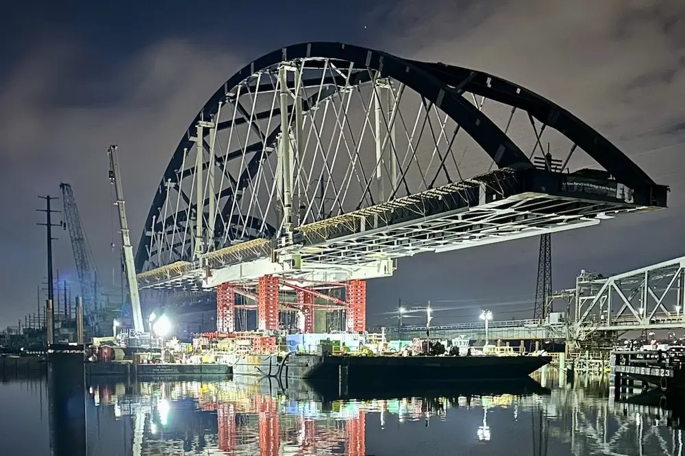 Crews work at night to place a main span arch. (Photo courtesy of Skanska-Traylor Joint Venture)