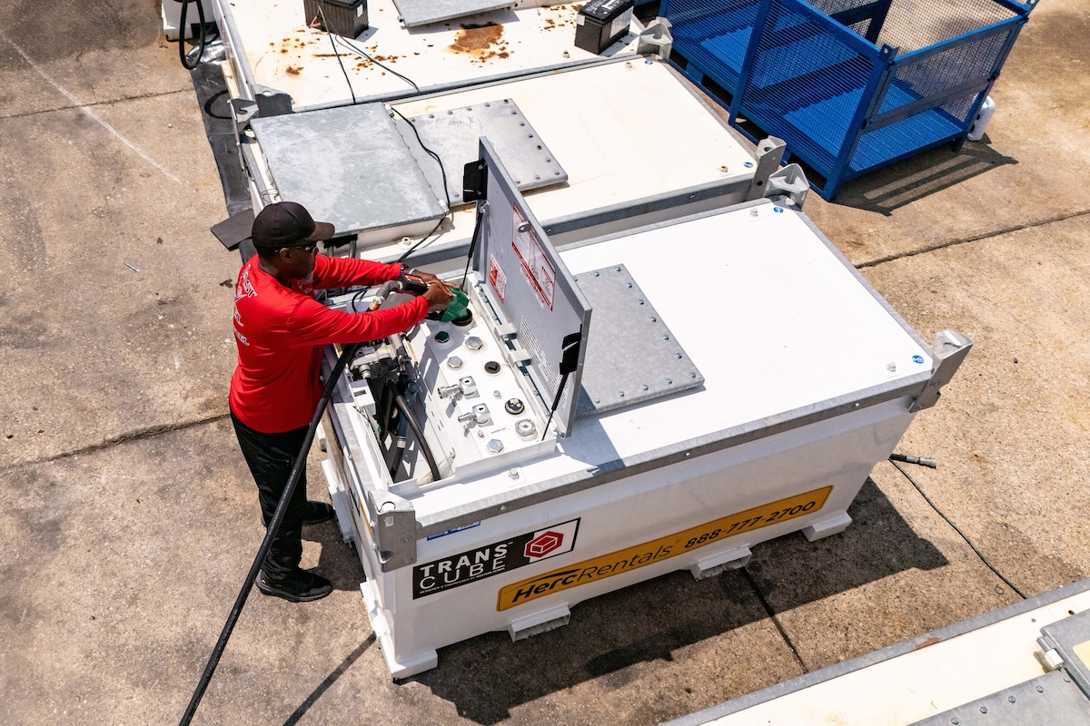 An employee fills a Western Global TransCube, a modern fuel tank that provides enhanced security against contamination and theft.