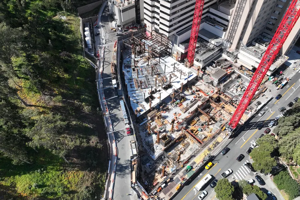The confined construction site offers very little room for material handling, logistics, or construction vehicles.
