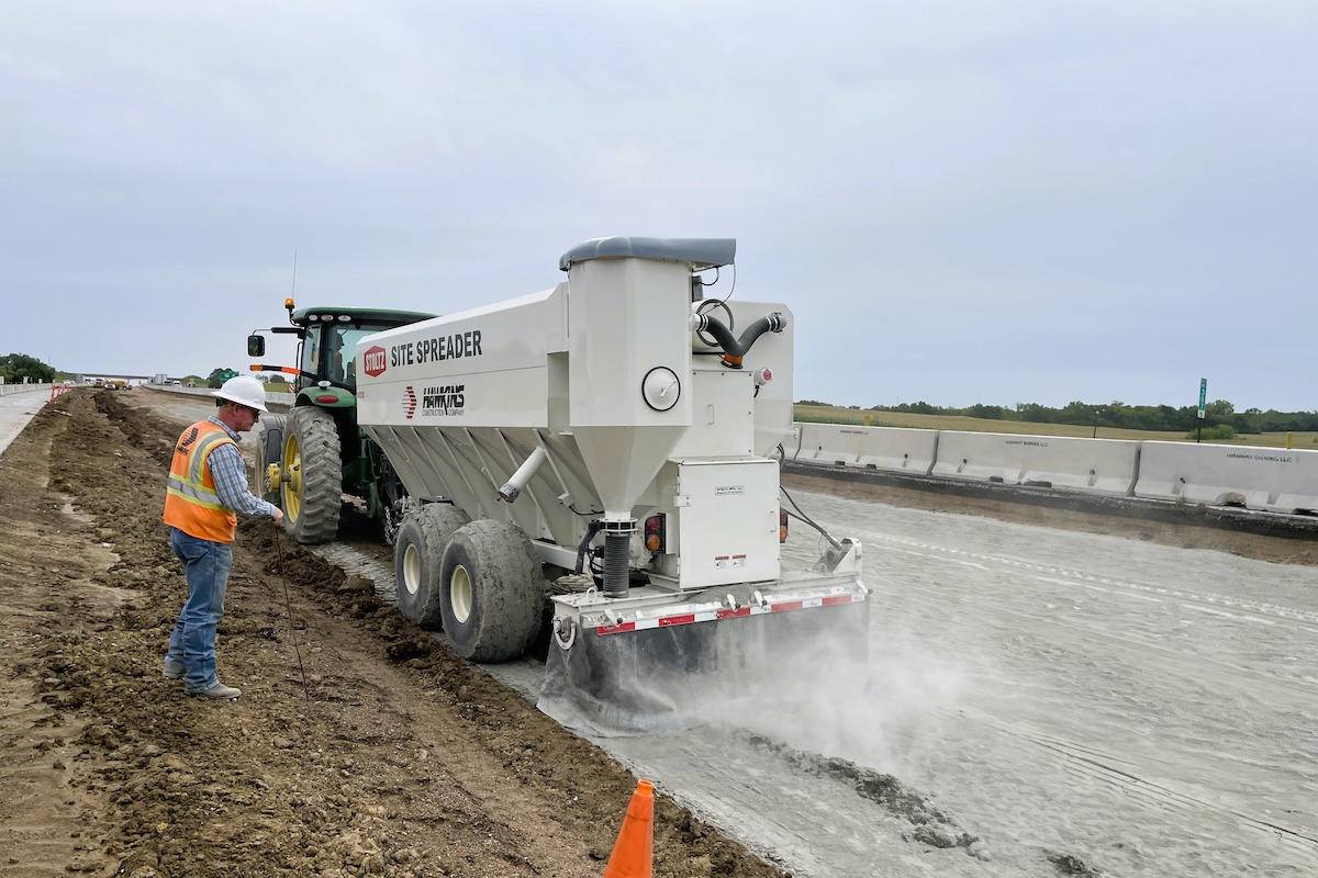 Superintendent Shawn Sleezer watches while a tractor spreads cement to be mixed into the subgrade for stabilization.