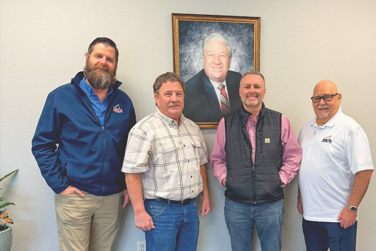 From left to right: Davis Crane Group's management team includes Director of Operations Jon Johnson, CEO Dennis Davis, COO Wes Dowd, and Executive Vice President of Business Services Keith McKee. The picture in the background is Raymond Davis, who started the company in 1962.