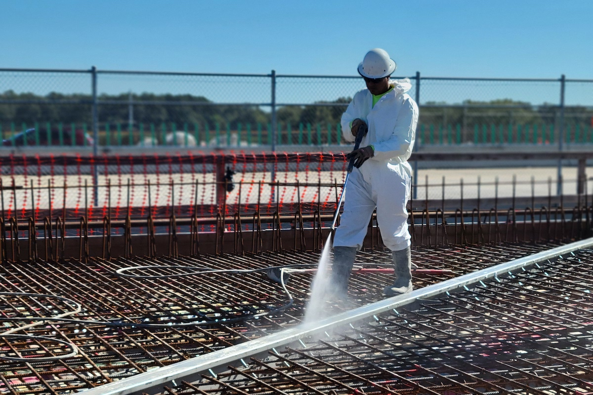 A crew member wets forms in preparation for the concrete pour.