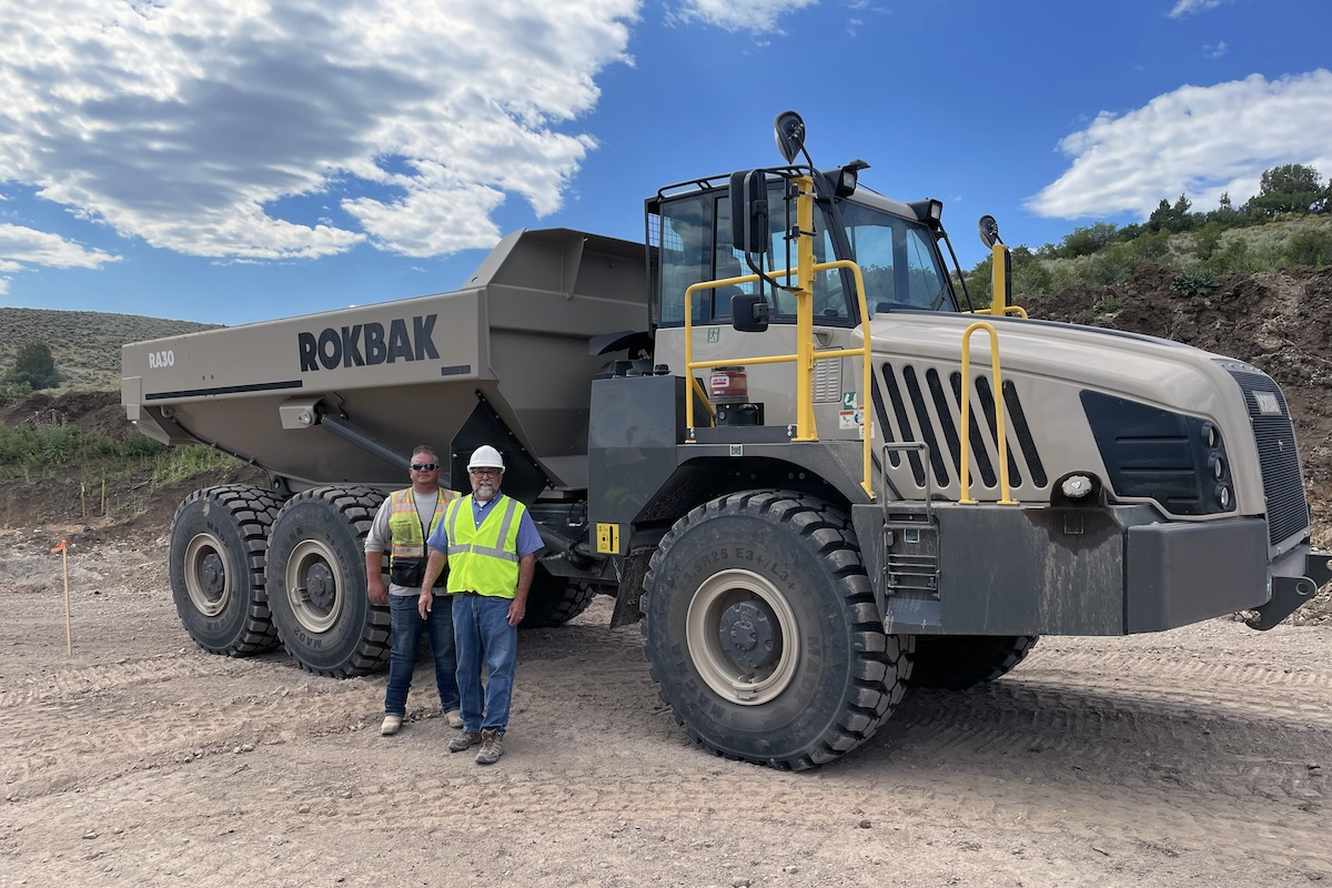 Jarrett Lindgren, Superintendent for Mark 25 Homes, and Randy Gallegos, President of Rasmussen Equipment, stand in front of a Rokbak RA30.