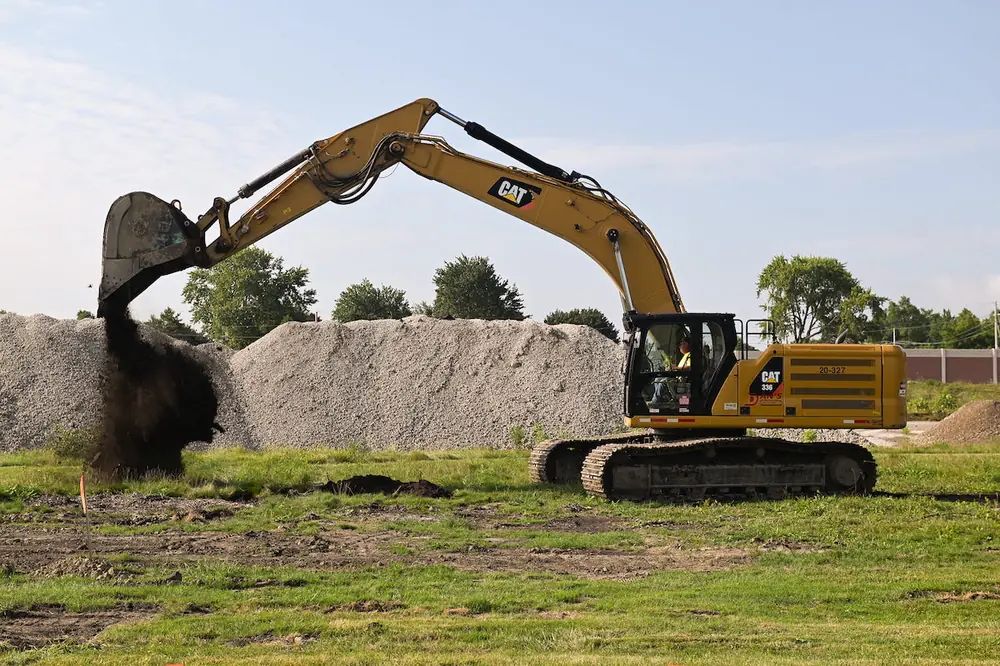 An excavator is used during the groundbreaking ceremony to commemorate the start of Component 2.