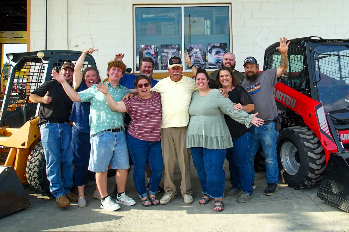 Lonnie Umdenstock (center) takes a photo with friends and family at his retirement party.