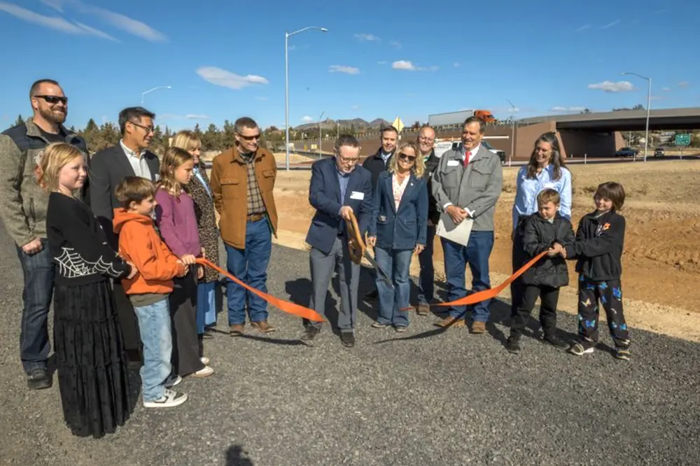 Interim ODOT Director Chris Warner cuts the ribbon being held by students from Terrebonne Community School at the ribbon-cutting event.