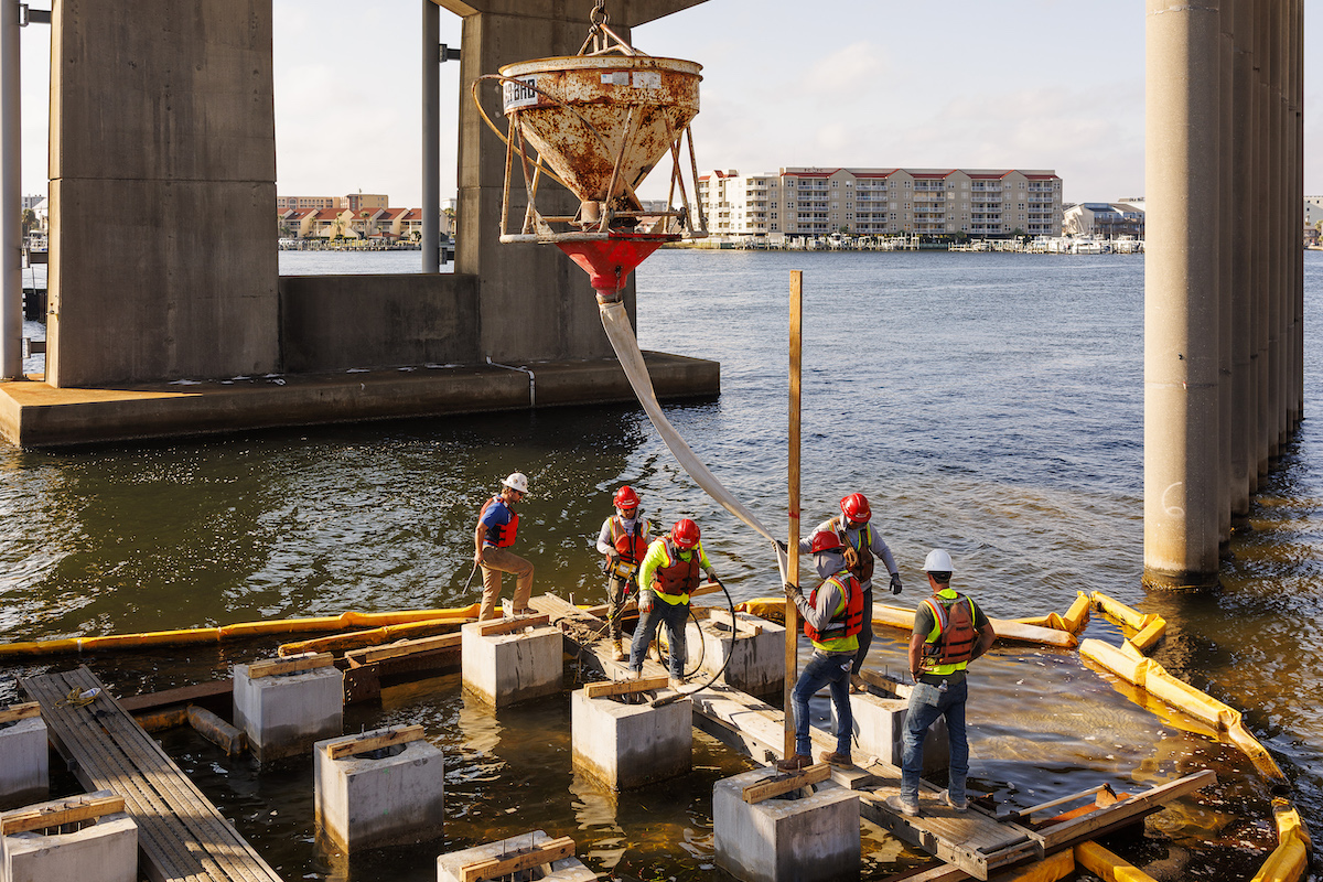 The Superior Construction crew coordinates complex marine concrete placement operations for the Brooks Bridge foundation work.